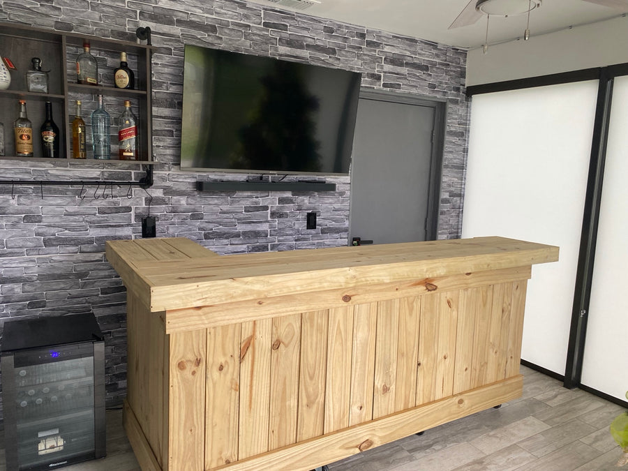 Natural wood straight bar in front of a stone-pattern television wall