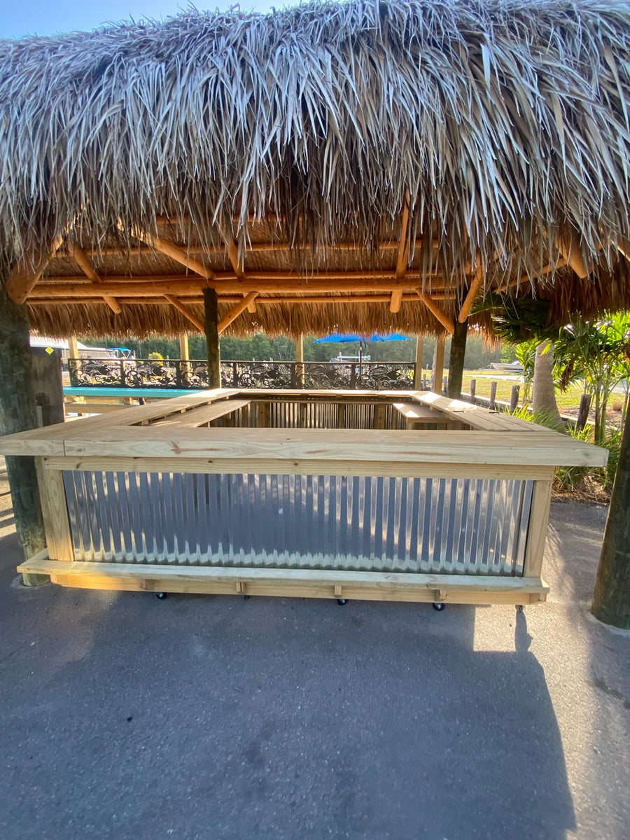 Wood and corrugated metal bar beneath a thatched outdoor shelter