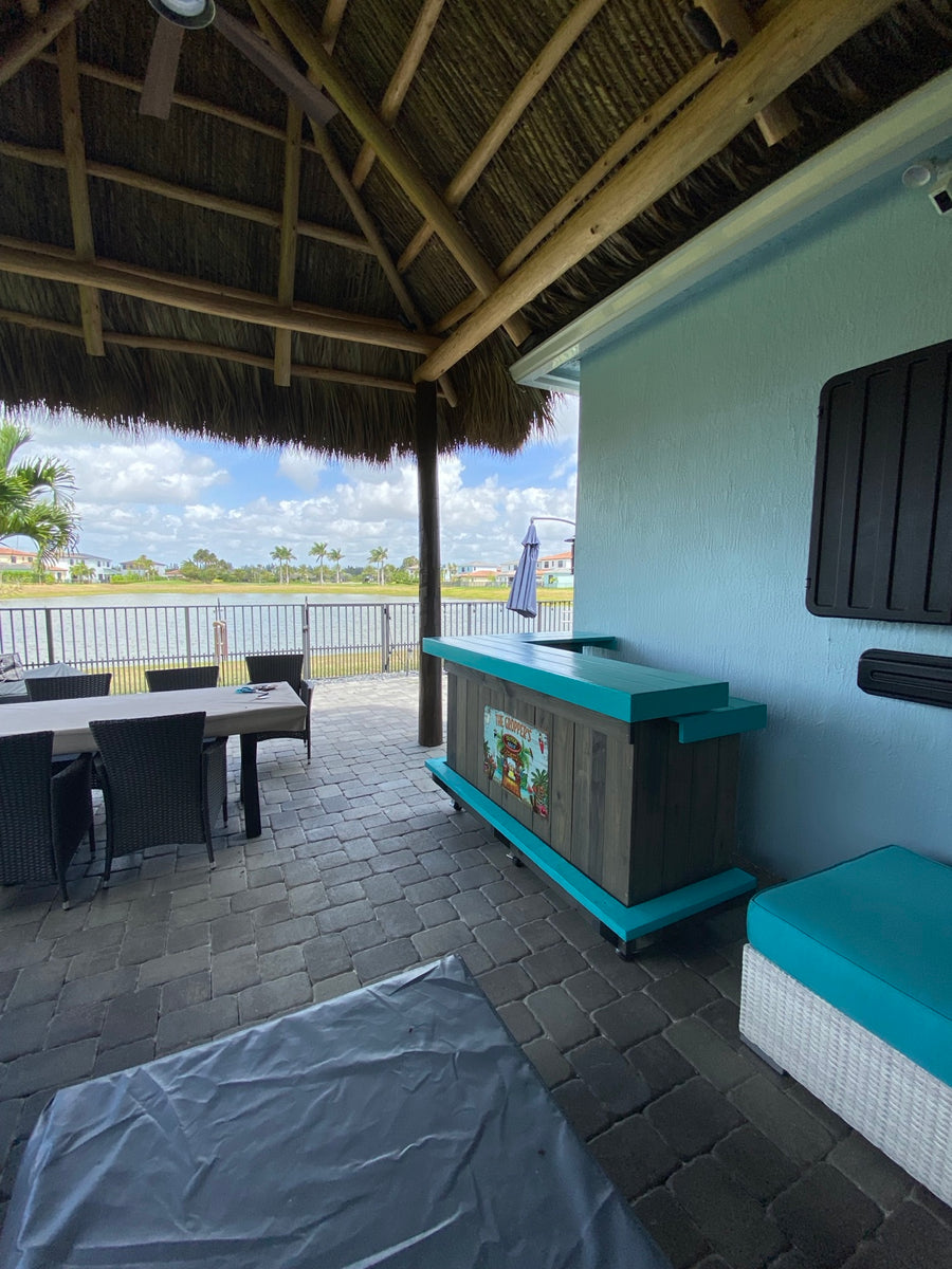 Gray wood bar with turquoise trim on a covered waterfront patio