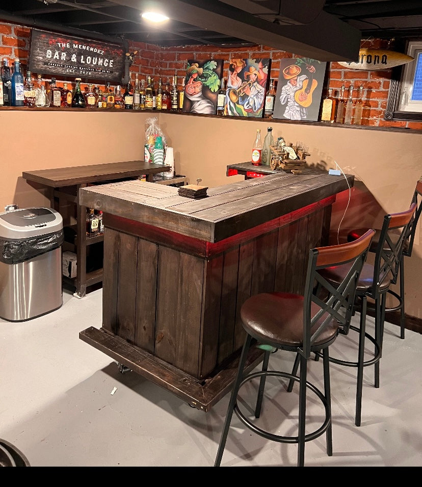 Dark wood bar with red accent lighting and metal-framed stools in a brick-walled basement