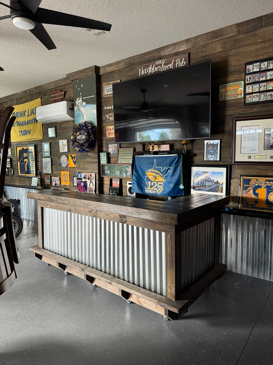Wood-framed metal-front bar beside a refrigerator in a wood-paneled room