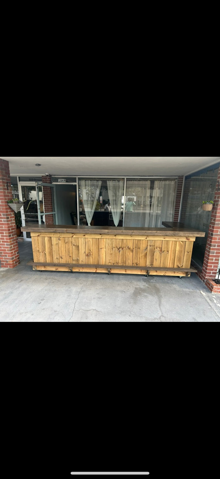 Long natural wood bar on a covered brick porch