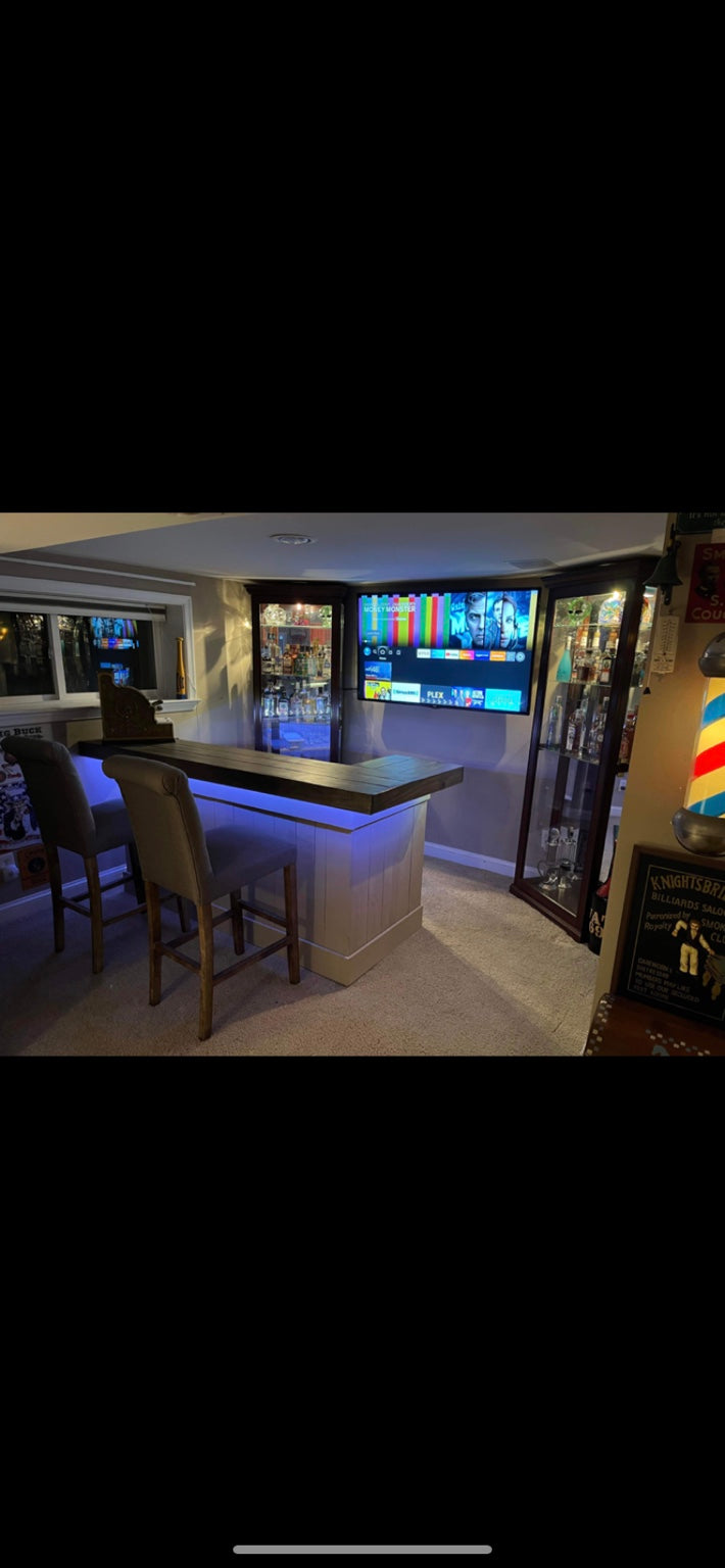White bar with a dark top and blue accent lighting in a home lounge